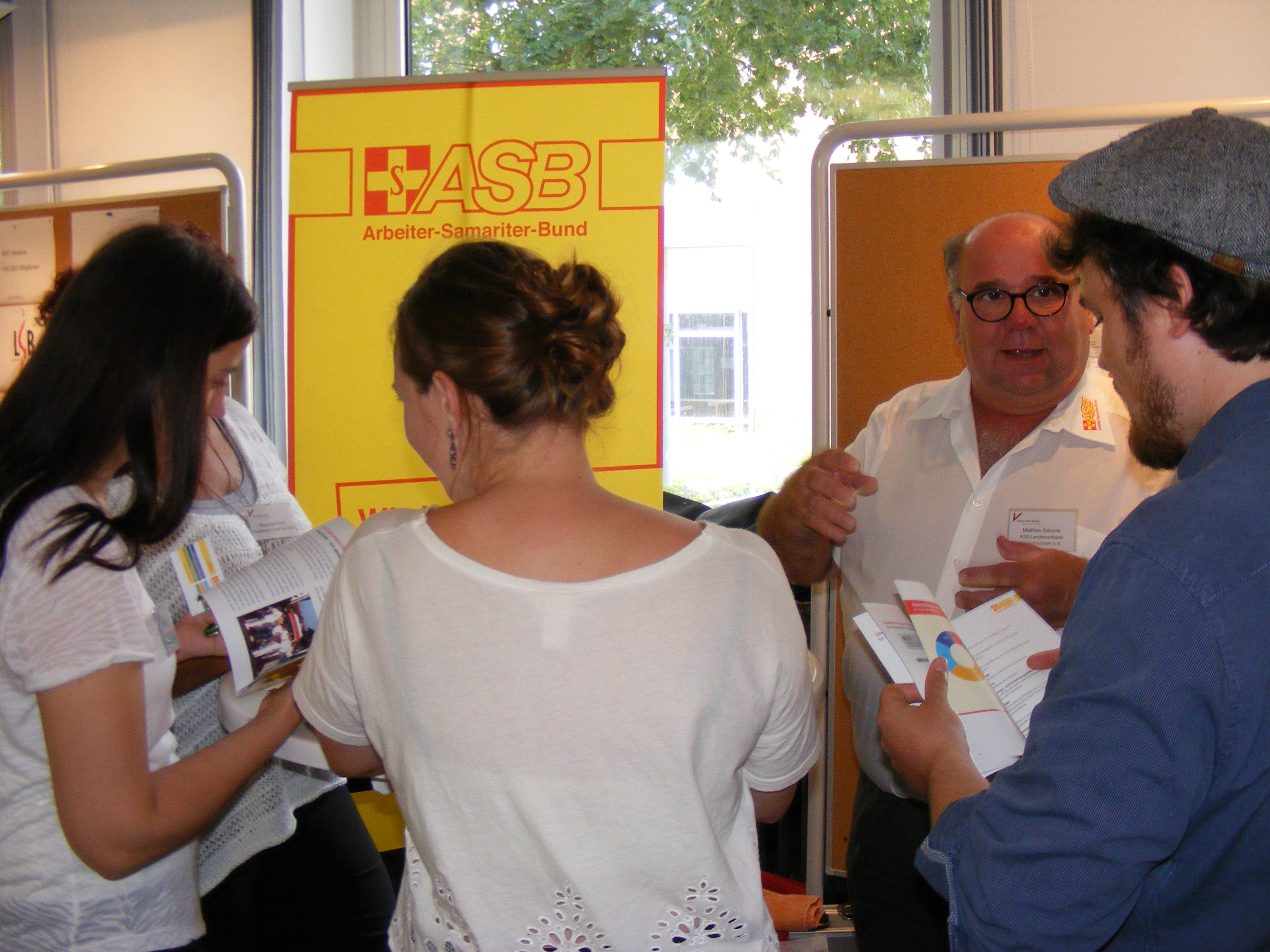 An einem Stand ist der Geschäftsführer des ASB Diepholz  Mathias Salomé im Gespräch mit Studierenden der Uni Vecha beim Carreer Day 2017.